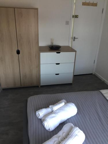 Duas toalhas numa cama num quarto com uma cómoda em Sama's Stylish Room 5 em Manchester