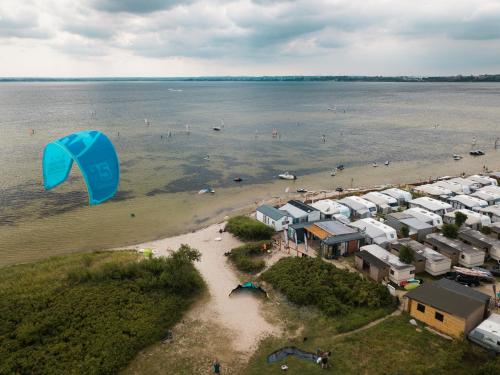a kite flying over a beach with a group of houses at Pokoje Surf People in Władysławowo
