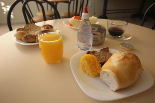 a table with two plates of breakfast foods and orange juice at Mosaico Hotel in Dianópolis