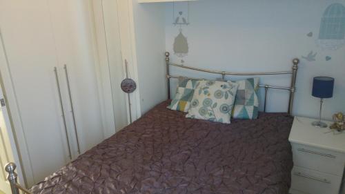 um quarto com uma cama com duas almofadas em cosy annex close to leeds airport em Guiseley