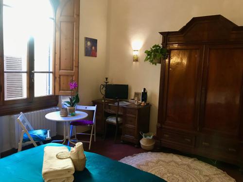 1 dormitorio con cama, escritorio y mesa en Strange Uncle B&B, en Florencia