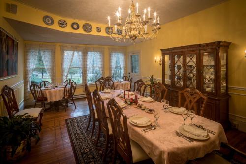 a dining room with a table and a chandelier at Taylor House Inn in Banner Elk