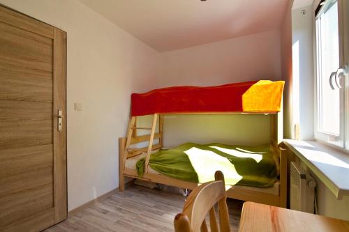 a small room with a bunk bed and a table at Luna in Mielenko