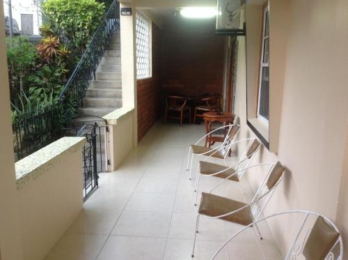 um corredor com cadeiras e escadas num edifício em Mitchell's Guest House em DʼArbeau