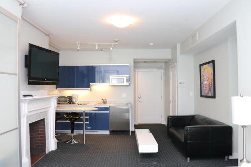 a living room with a black couch and a kitchen at Stylish Newbury Street Studio, #4 in Boston