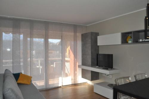 a living room with a couch and a television at Casa Lu in Levico Terme