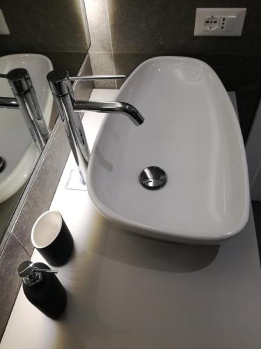 a white sink in a bathroom next to a mirror at Casa Lu in Levico Terme