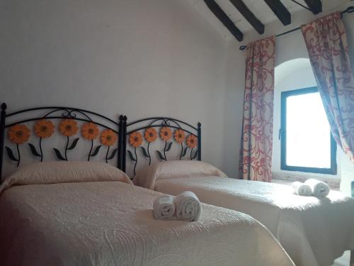 a bedroom with two beds with towels on them at Apartamento Sierra de Grazalema in Prado del Rey