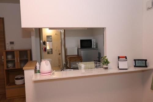 a kitchen with a counter top with a mirror at Reussir yamahanaminami 103 in Sapporo