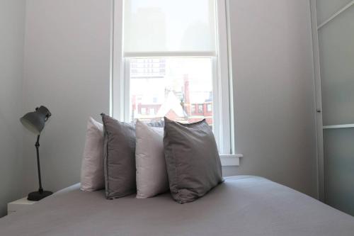 een slaapkamer met een bed met kussens en een raam bij Comfortable Studio in Back Bay, Newbury St. #7 in Boston