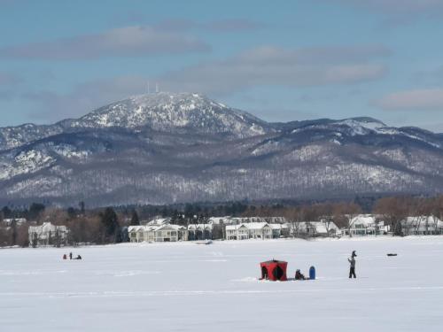 a group of people in the snow with a mountain at Condo de L'Oberge in Magog-Orford