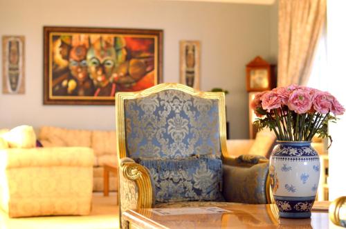 a vase of flowers sitting on a table with a chair at Rehoboth Mountain Suites in Mbabane