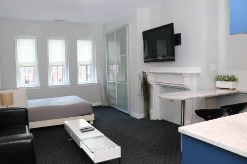 a hotel room with a bed and a tv at Stylish Studio on Newbury St, THIS IS BOSTON! #12 in Boston