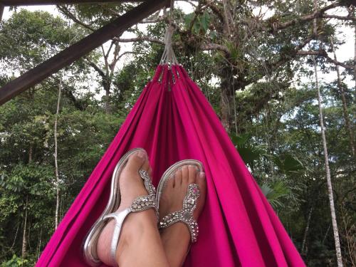 a person with their feet in a pink hammock at La Casa del Rio B&B in Puyo