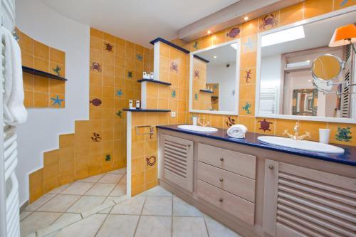 baño con 2 lavabos y espejo grande en Villa Le Lagon - Vision Luxe, en Bonifacio