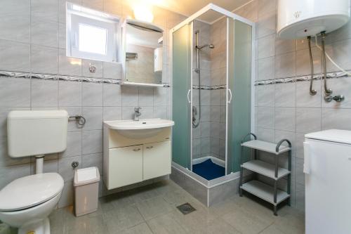 a bathroom with a toilet sink and a shower at Apartments Posavec in Pinezici