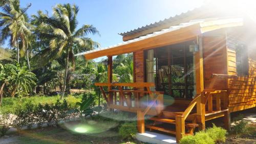 a small wooden house with a porch and some palm trees at Home No.9 in Ko Lanta