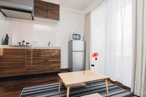 uma cozinha com uma mesa e um frigorífico em Juso AFP Apartment Hotel em Osaka