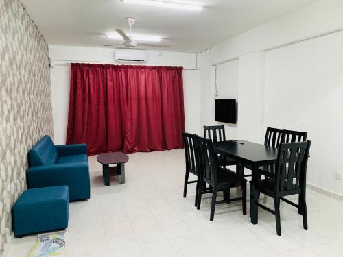 a dining room with a table and chairs and a red curtain at Town City Home sweet home in Kuala Terengganu