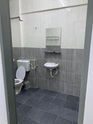 a bathroom with a toilet and a sink at Town City Home sweet home in Kuala Terengganu
