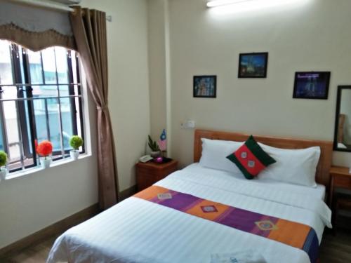 a bedroom with a bed and a window at Chau A Hotel in Hải Dương