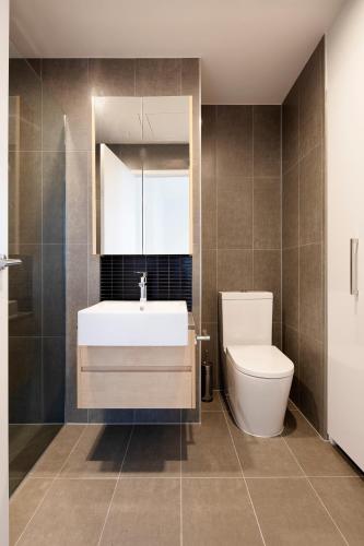 a bathroom with a white sink and a toilet at Artel Apartments Brunswick in Melbourne