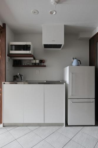 a kitchen with white counters and a white refrigerator at 京都 六花庵 Kyoto Rokkaan in Kyoto