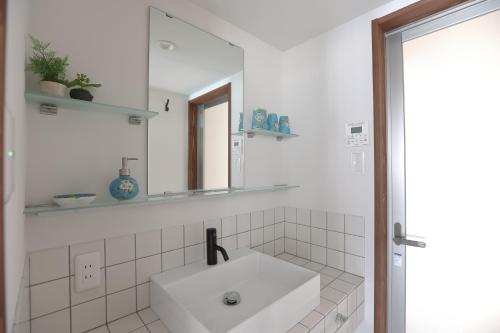 a white bathroom with a sink and a mirror at 京都 六花庵 Kyoto Rokkaan in Kyoto