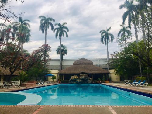 a large swimming pool in a tropical setting at Hotel Valles in Ciudad Valles