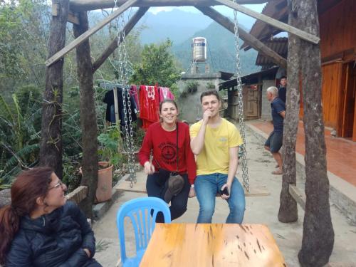 a man and a woman sitting at a table in a swing at ChienDe Homestay in Sa Pa