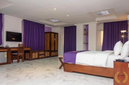 a hotel room with a bed and a table and a desk at Residence Maryka II in Cotonou