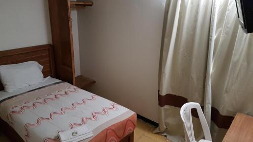 a small room with a bed and a curtain at Departamento 7/7 in Tlaxcala de Xicohténcatl