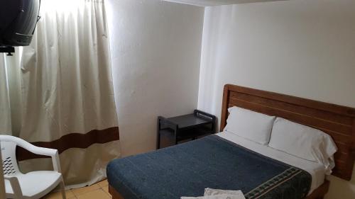 una camera con un letto e una sedia e una finestra di Departamento 7/7 a Tlaxcala de Xicohténcatl
