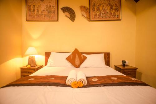 a bedroom with a bed with two nightstandiatesiatesiatesiatesiatesiatesiates at Kamar Suci House in Ubud