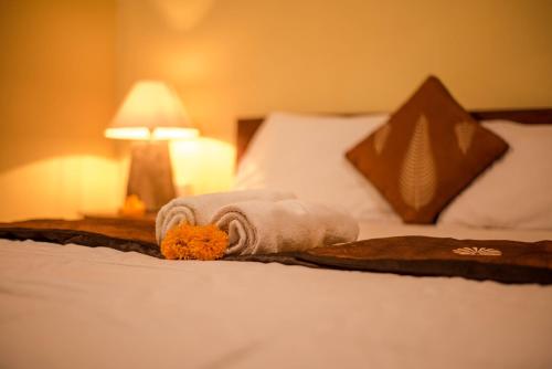 a bed with towels and a teddy bear on it at Kamar Suci House in Ubud