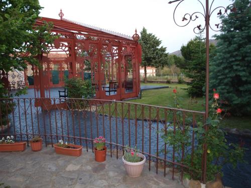 a fence with potted plants and a gazebo at Posada del Indiano in Cidones