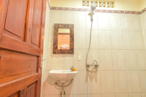 ein Bad mit einem Waschbecken und einer Dusche in der Unterkunft Kamar Suci House in Ubud
