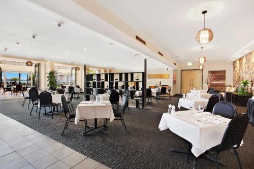 a dining room with white tables and chairs and tablesearcher at Comfort Resort Waters Edge in Port Macquarie