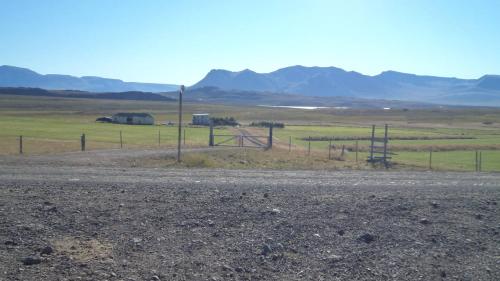 a fence on the side of a road with mountains in the background at Syðri-Þverá in Hvammstangi