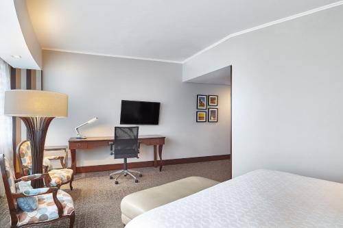 a hotel room with a bed and a desk with a computer at Hilton Porto Alegre, Brazil in Porto Alegre