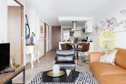 a living room and kitchen with a couch and a table at Departamento en Polanco con Impresionante vista a la ciudad GYM - POOL - PARKING in Mexico City