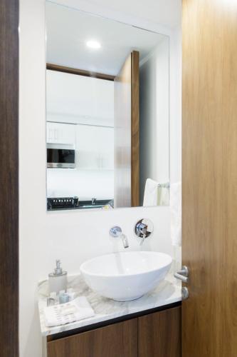 a bathroom with a white sink and a mirror at Departamento en Polanco con Impresionante vista a la ciudad GYM - POOL - PARKING in Mexico City