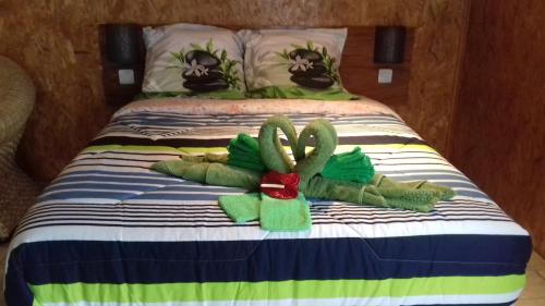 Una cama con dos animales de peluche. en Ferme Lebon Papillon le chalet kayamb, en Le Tampon