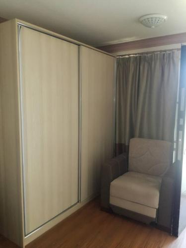 a room with a chair and a sliding glass door at Paradise Investment Resort in Tʼelavi