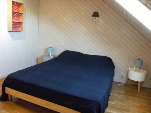 a bedroom with a blue bed in a attic at Villa Toscana 250 M de la plage in Agon-Coutainville
