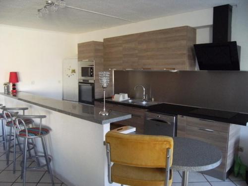 une cuisine avec un comptoir et un bar avec tabourets dans l'établissement Villa Toscana 250 M de la plage, à Agon-Coutainville