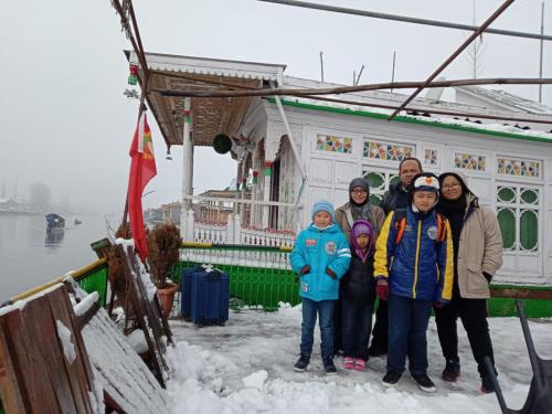 a group of people standing in front of a house in the snow at S Group Of Houseboat in Srinagar