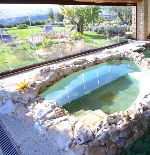 a swimming pool in a house with a large window at Luxury villa Colle dell'Asinello ,proprietari ,Villa In esclusiva near ORVIETO in Guardea