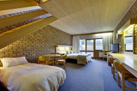 a hotel room with two beds and a tv at Flinders Cove Motel in Flinders