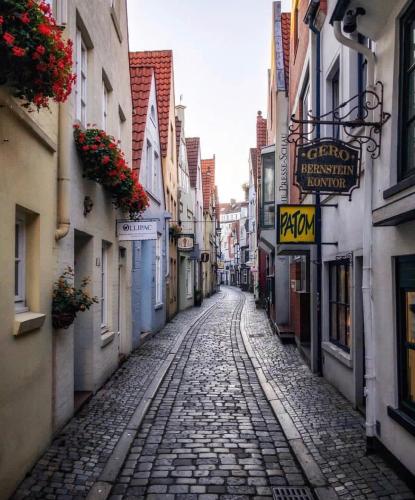 an empty street in an alley with buildings and flowers at Hotel Edel Weiss in Bremen